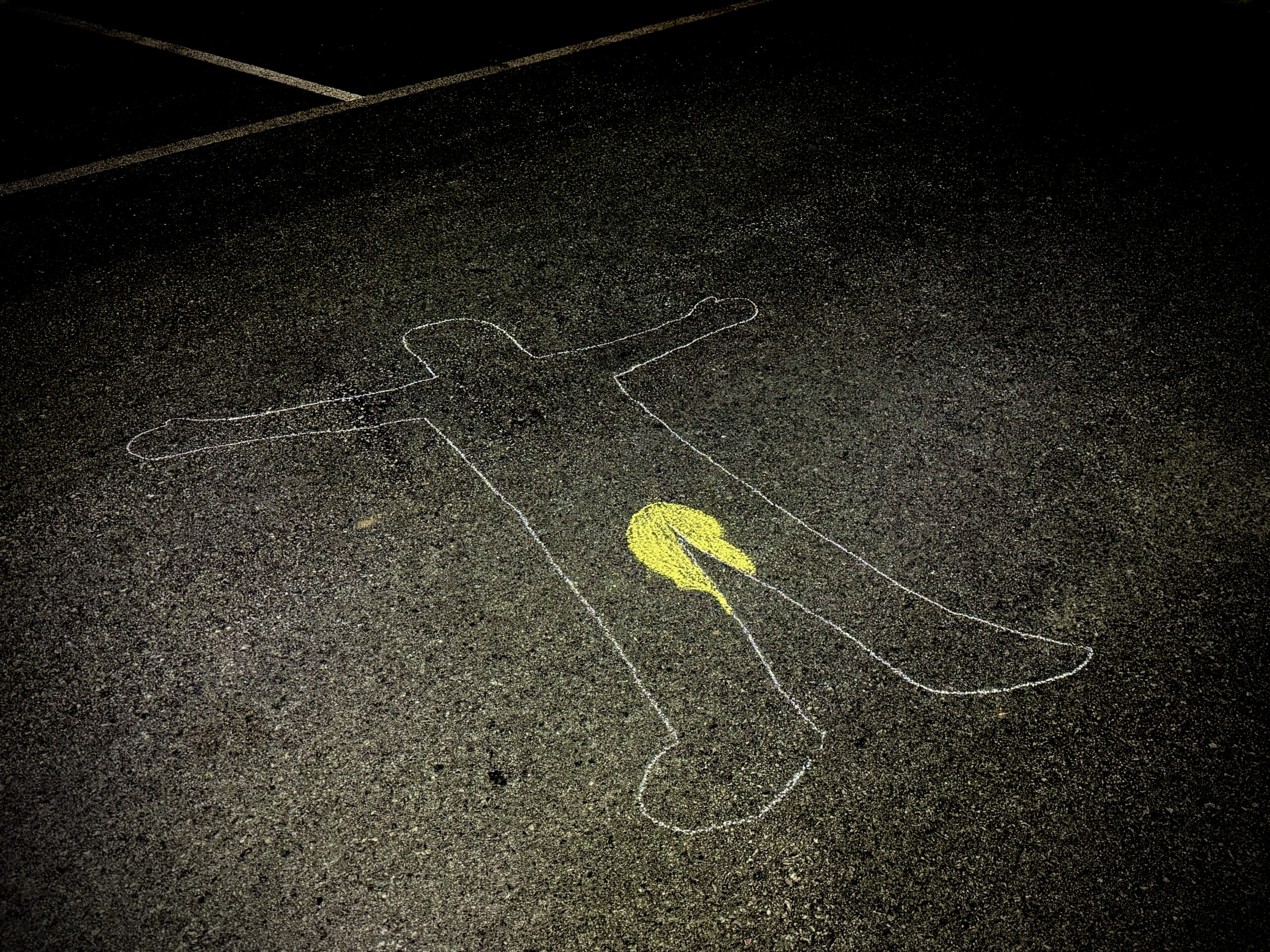 Chalk outline of a body including a pee stain between the legs